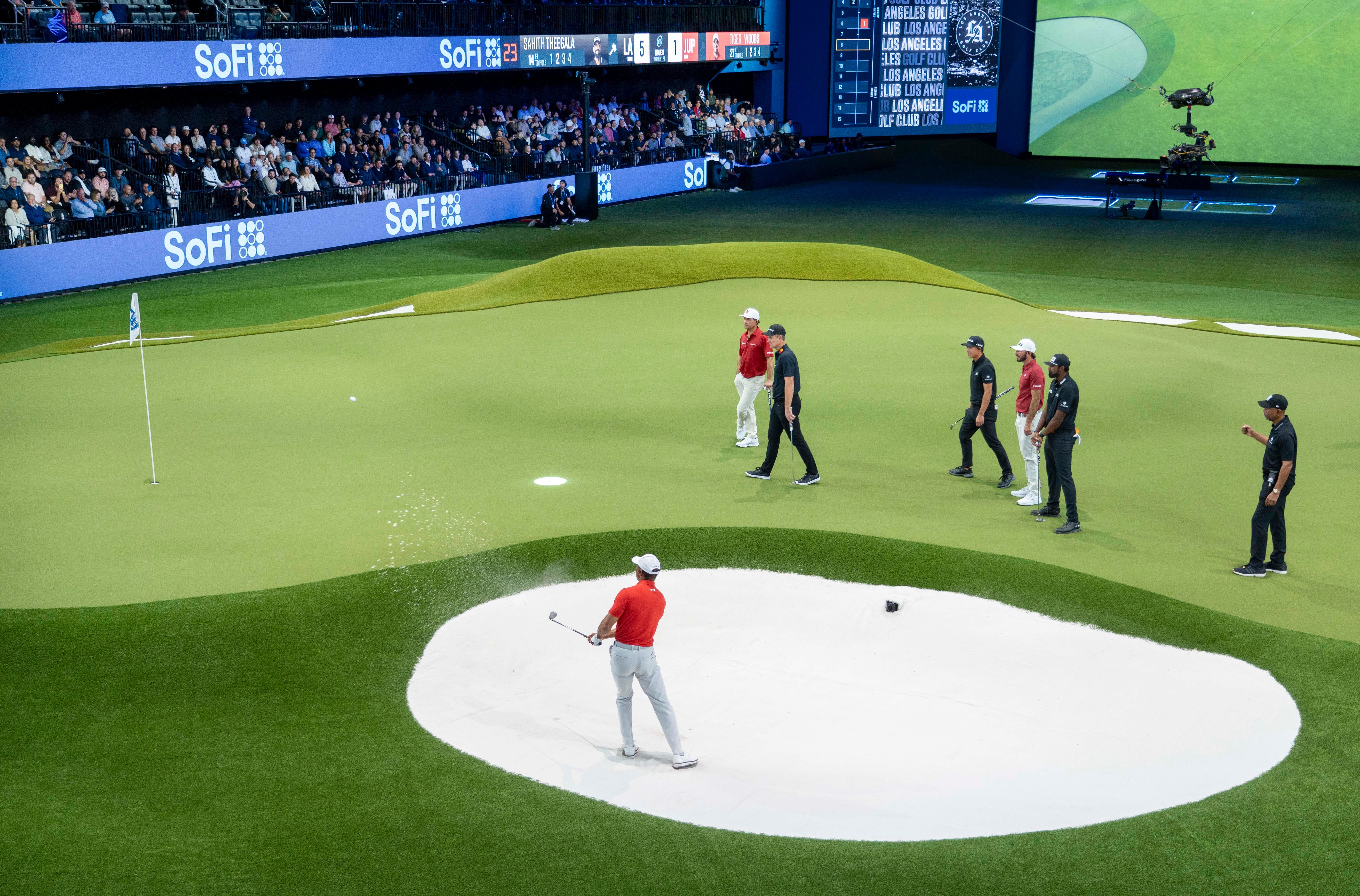Tiger Woods prepares to hit the ball out of the bunker during a match at SoFi Center.