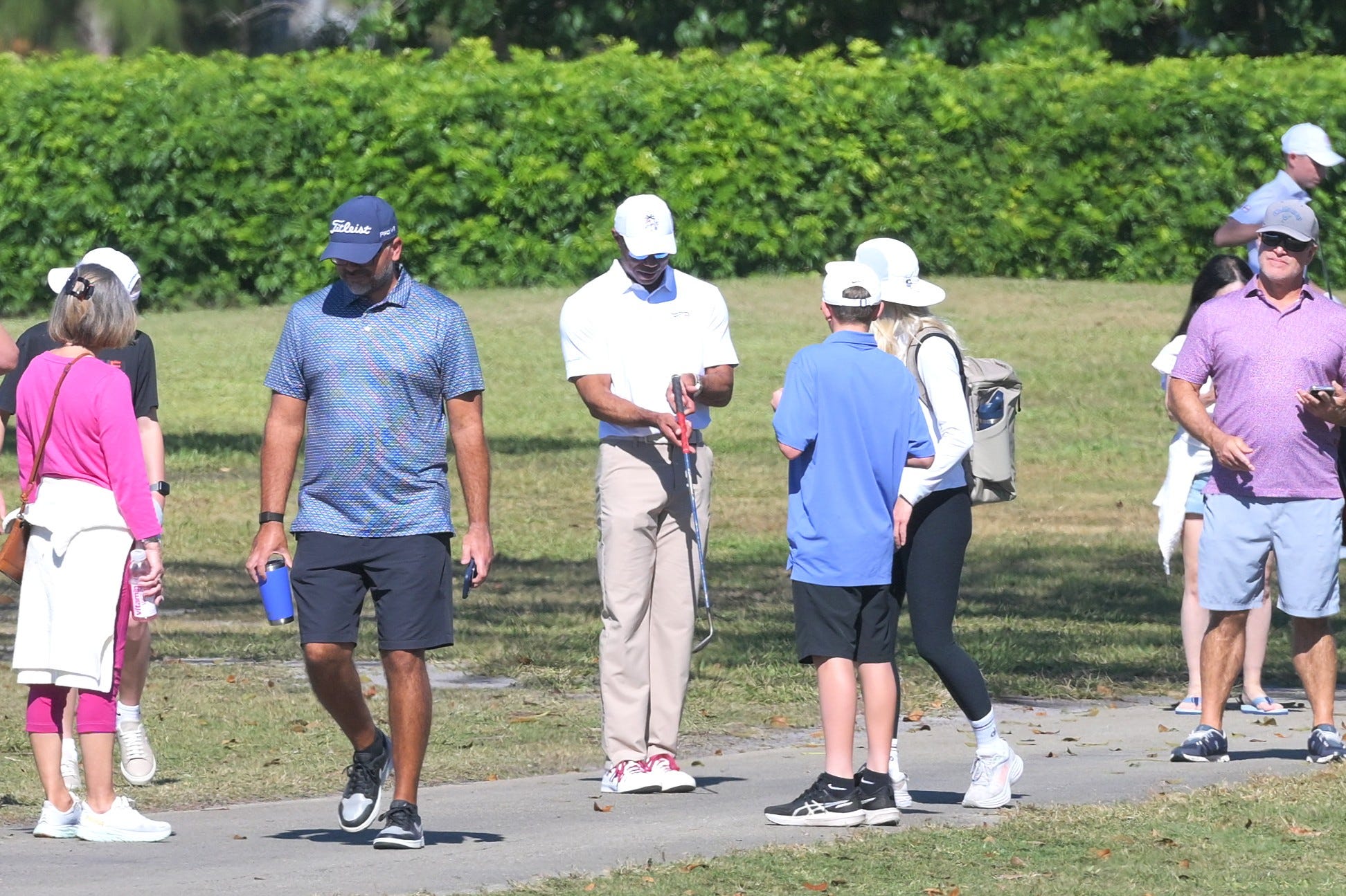 Tiger Woods examines Charlie's club after it encountered tree roots